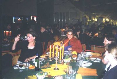 Lisbet kigger i glasset og Niels Jeppesens nevø i baggrunden
